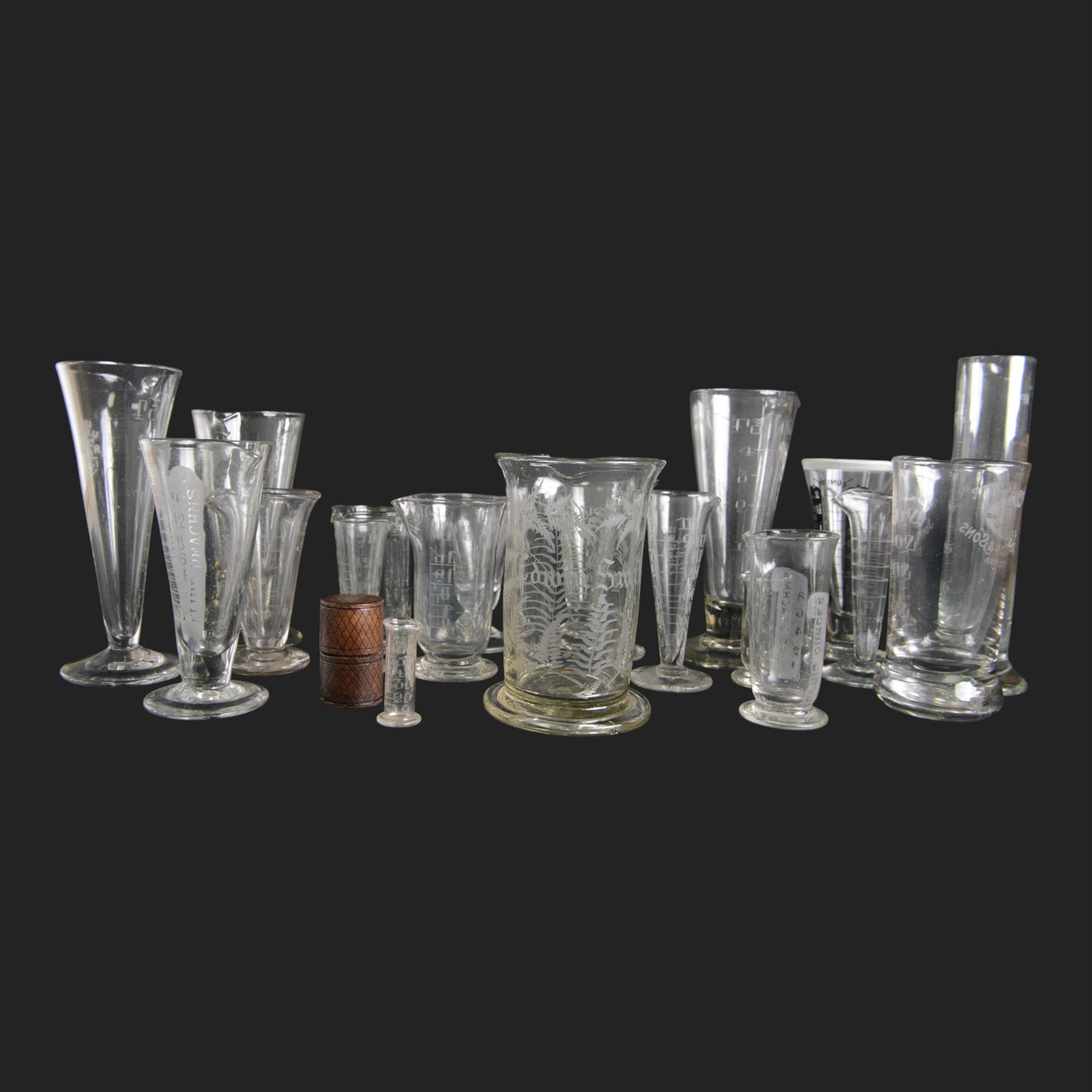 Nineteen apothecary chemists glass measures, of various shapes and age 