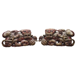  Pair of Chinese carved and red painted wood Temple Lions and  cubs, paw resting on a pierced ball, L102cm, H44cm, D38cm (2)  