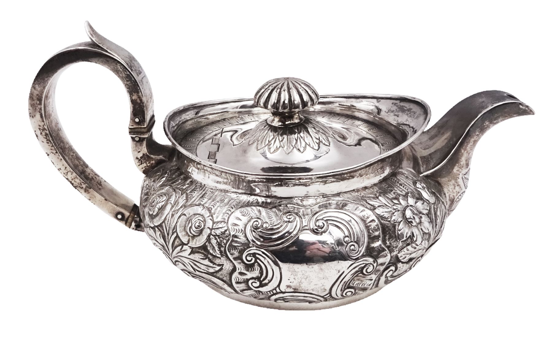 George III Irish silver teapot, of squat circular form, the body with repousse and chased floral and C scroll decoration, with capped C handle and ivory insulators, engraved to base 'Presented to Troop Sergeant Major John Percival, of the 4th Dragoon Guards by Alex D. Tait, Esq, late Captain in that corps as a mark of approbation of his steady and upright conduct when Sergeant Major of his Troop, Dublin, June 2nd 1843', hallmarked William Law, Dublin 1817, H12.5cm, This item has been registered for sale under Section 10 of the APHA Ivory Act