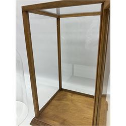 Tabletop glass display cabinet, with hinged door, together with two glass domes