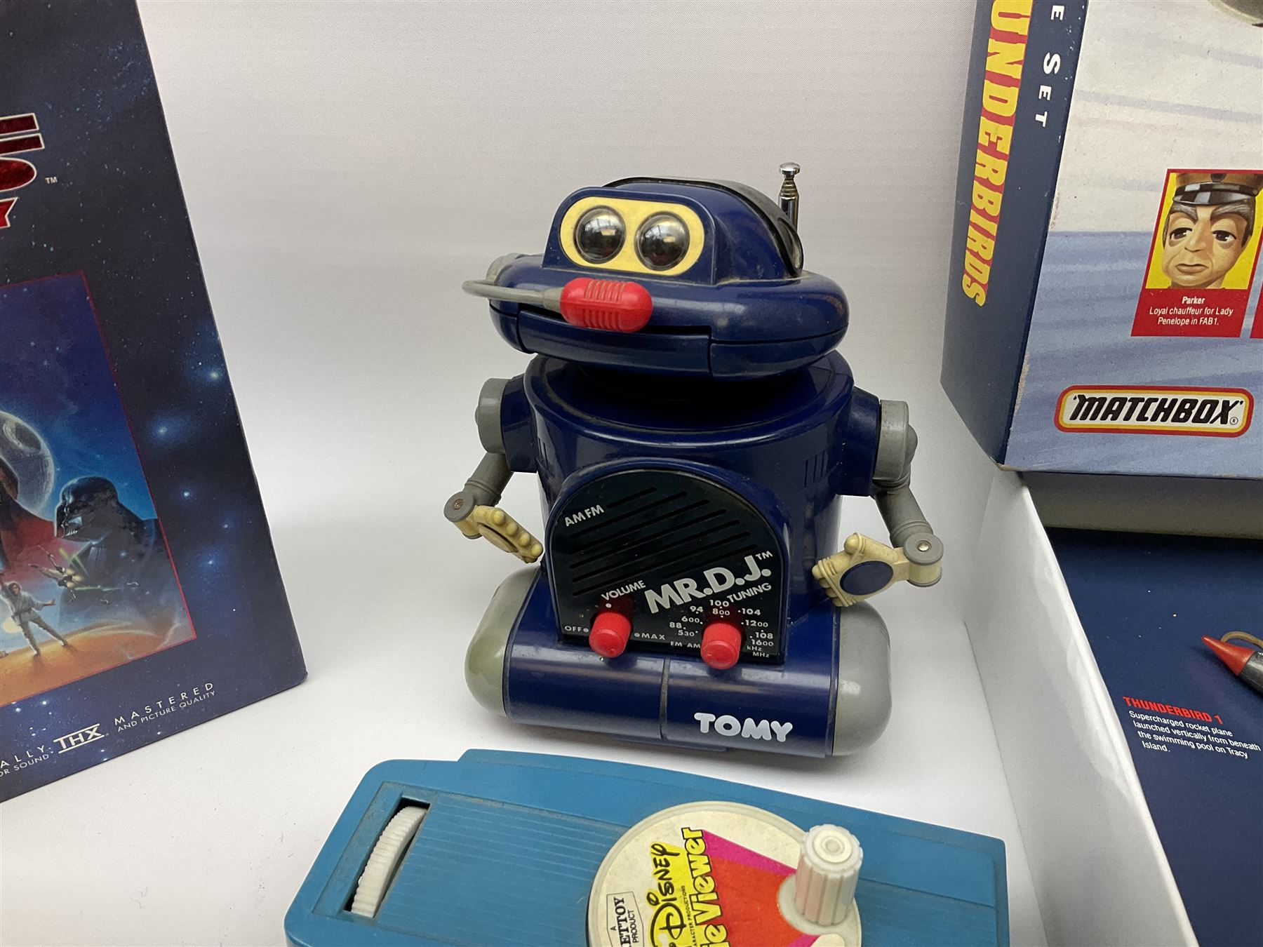 Matchbox 'The Thunderbirds' limited edition Commemorative Set, boxed with paperwork; Tomy 'Mr. D.J.' blue plastic robot radio; Mettoy Walt Disney Movie Viewer with three cassettes; and 1995 boxed set of the Star Wars trilogy VHS video tapes