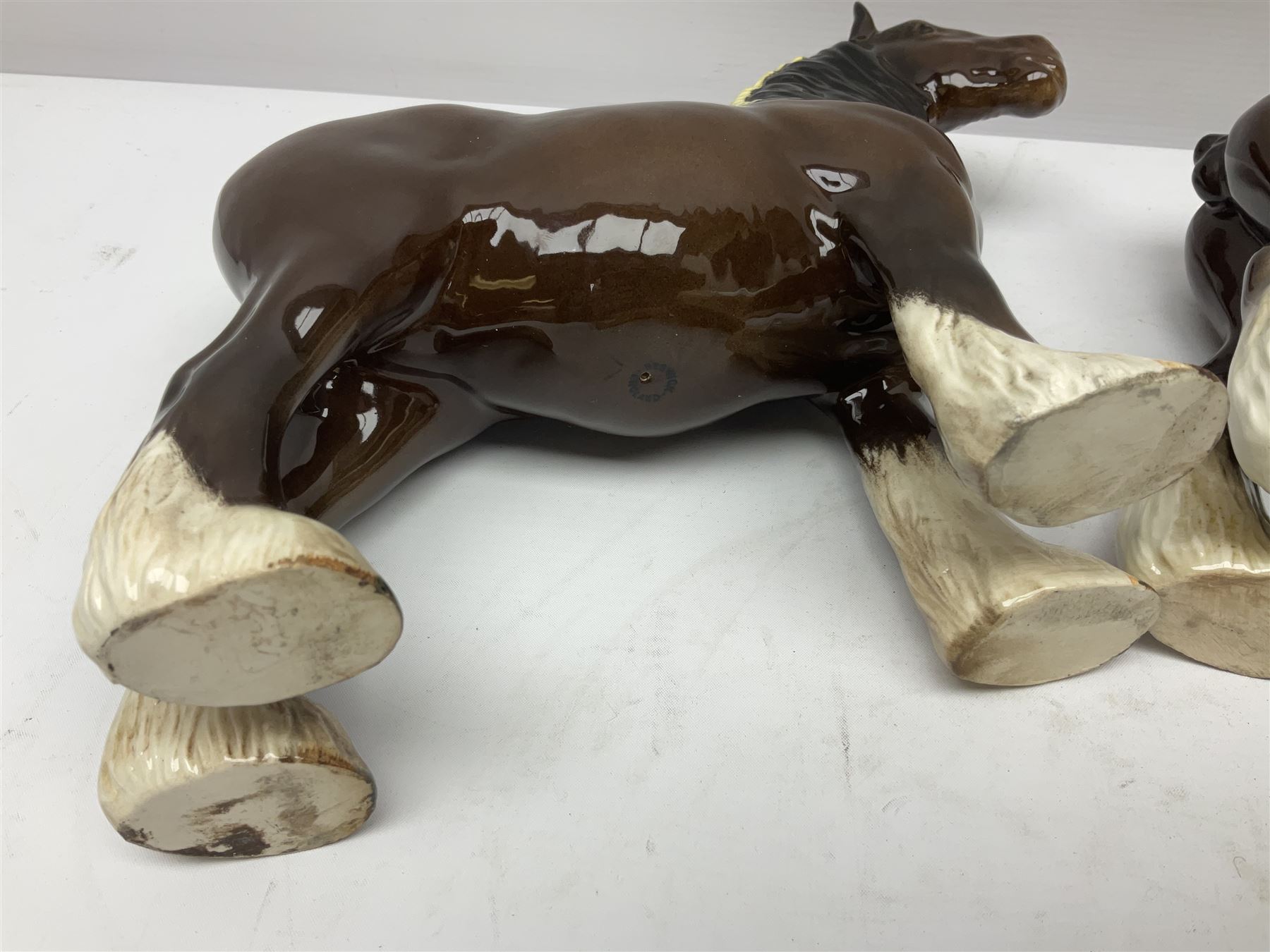 Four Beswick horse figures, comprising Quarter Horse, two Shires no 818 and matt palomino, together with Beswick donkey and Royal Doulton horse on a wooden plinth  