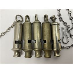 Three Hull City Police 'Metropolitan' whistles by J. Hudson 13 Barr Street Birminham, each with impressed collar number; another 'Metropolitan' police whistle with chain; and an ARP whistle by Hudson & Co with chain (5)