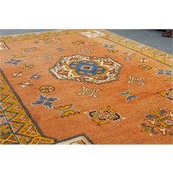 Turkish Anatolian hand-knotted carpet, salmon ground centred by a blue and cream octagonal medallion, scattered with geometric floral and tribal motifs, cream spandrels and yellow geometric border