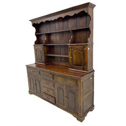 Traditional oak dresser, the moulded cornice over shaped apron, three heights plate rack fitted with two cupboards, the base fitted with six drawers and two double cupboards, panelled pointed ogee arched doors, on bracket feet