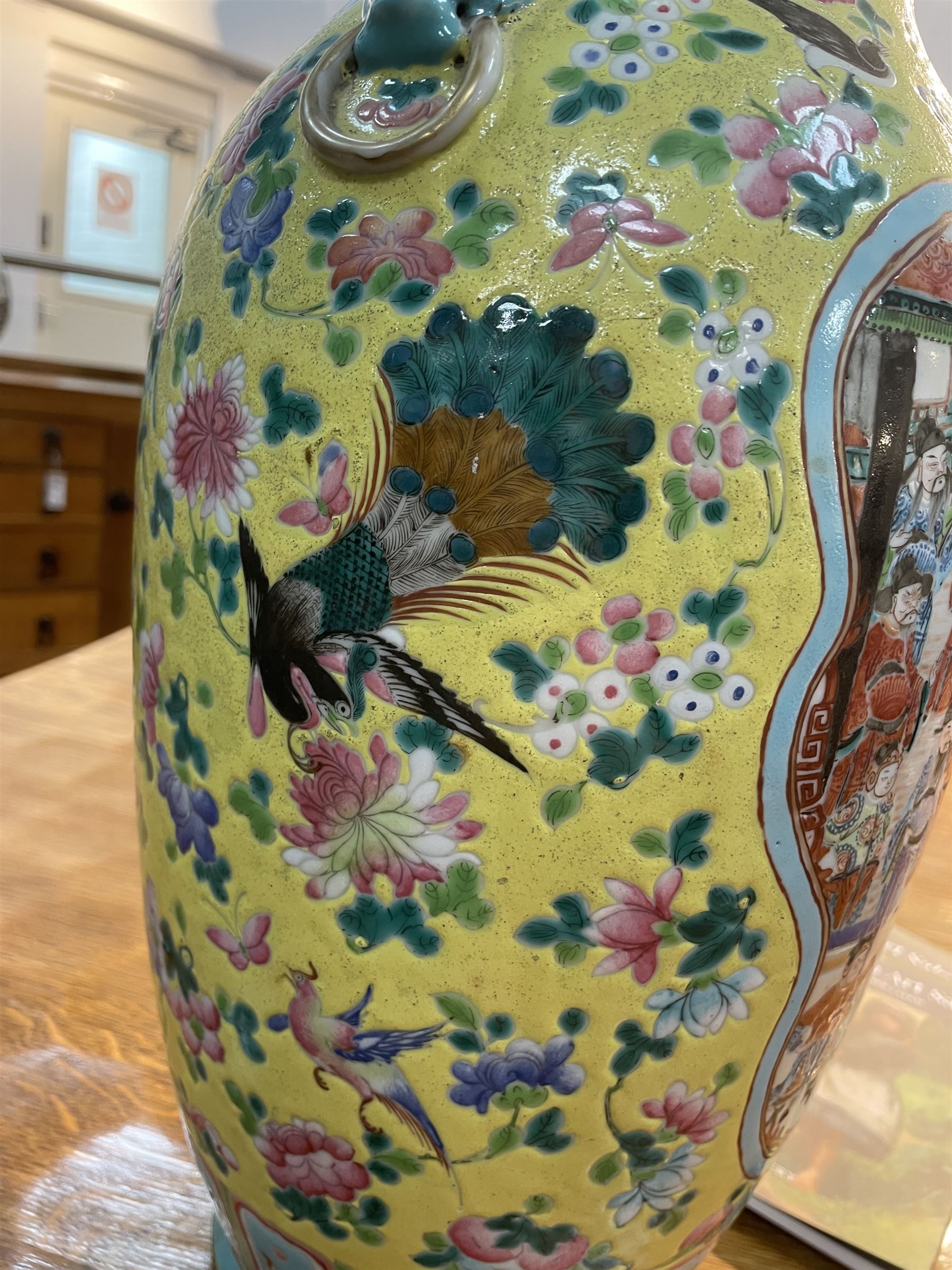 19th century Chinese famille rose yellow ground porcelain vase, of baluster form with twin applied mask ring handles, the body decorated with two shaped reserves mounted with dragon heads, depicting warriors at battle and at court, the neck with two smaller conforming figural reserves, upon a yellow ground decorated with exotic birds amidst scrolling blossom, H45.cm