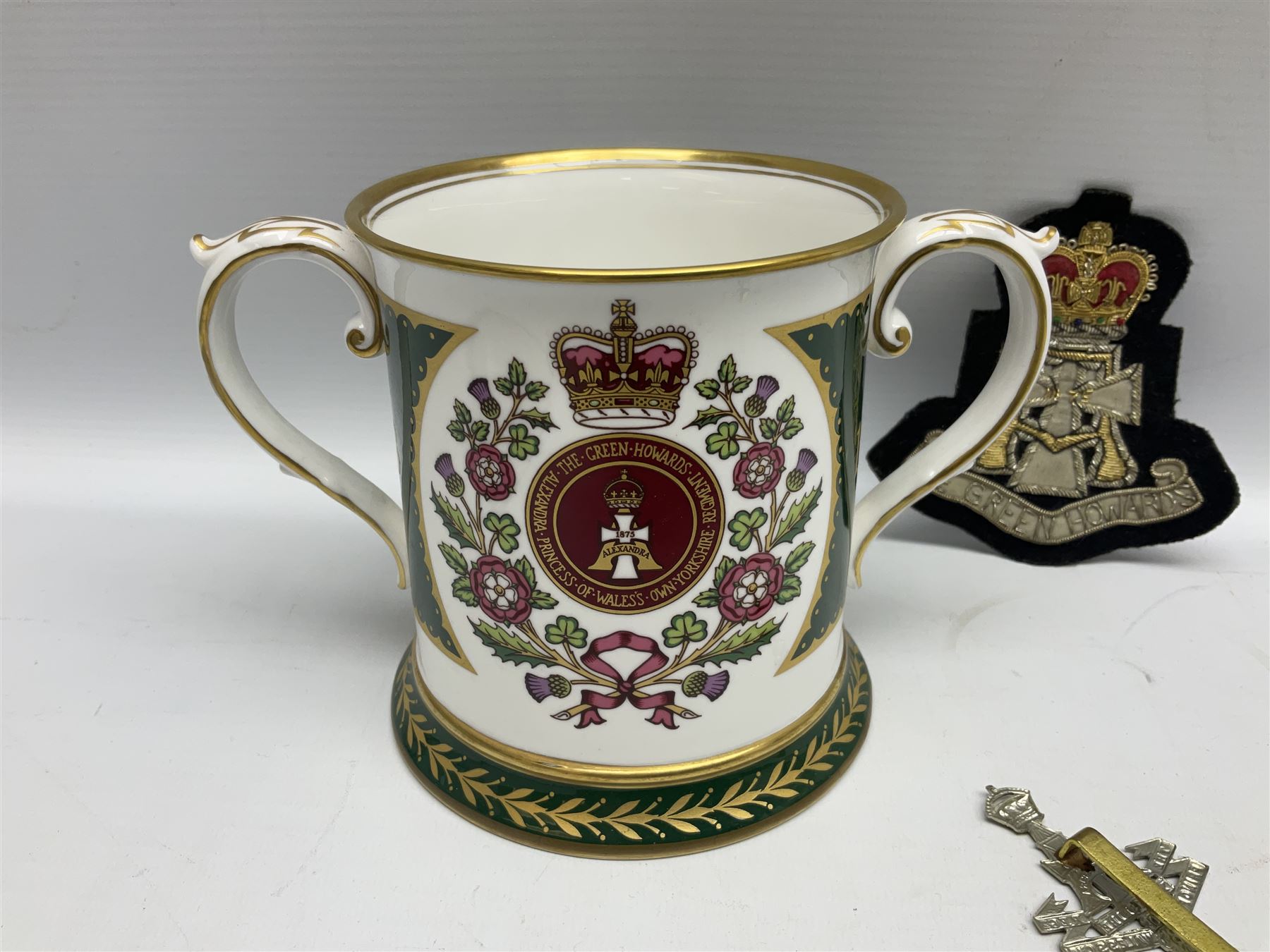 Limited edition Spode Green Howard's twin handled loving mug, no 205/300, with certificates, together with a Green Howards cased Tercentenary medal (1688-1988), cap badge and embroidered patch, largest H11.5cm