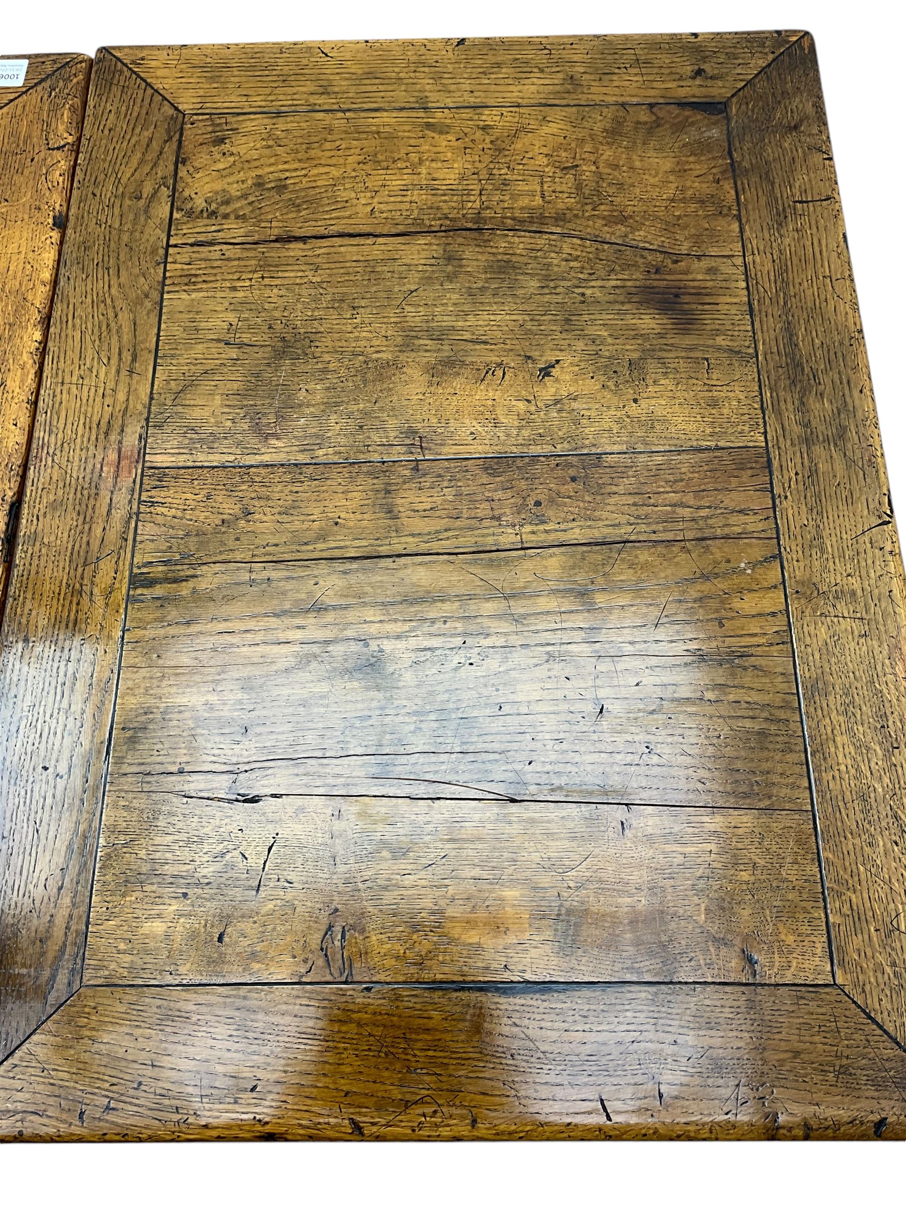 Early 20th century Jacobean design draw-leaf oak dining table, rectangular top with carved frieze depicting scrolling foliage and grape clusters, sliding extending leaves, raised on robust turned supports united by H-stretcher  