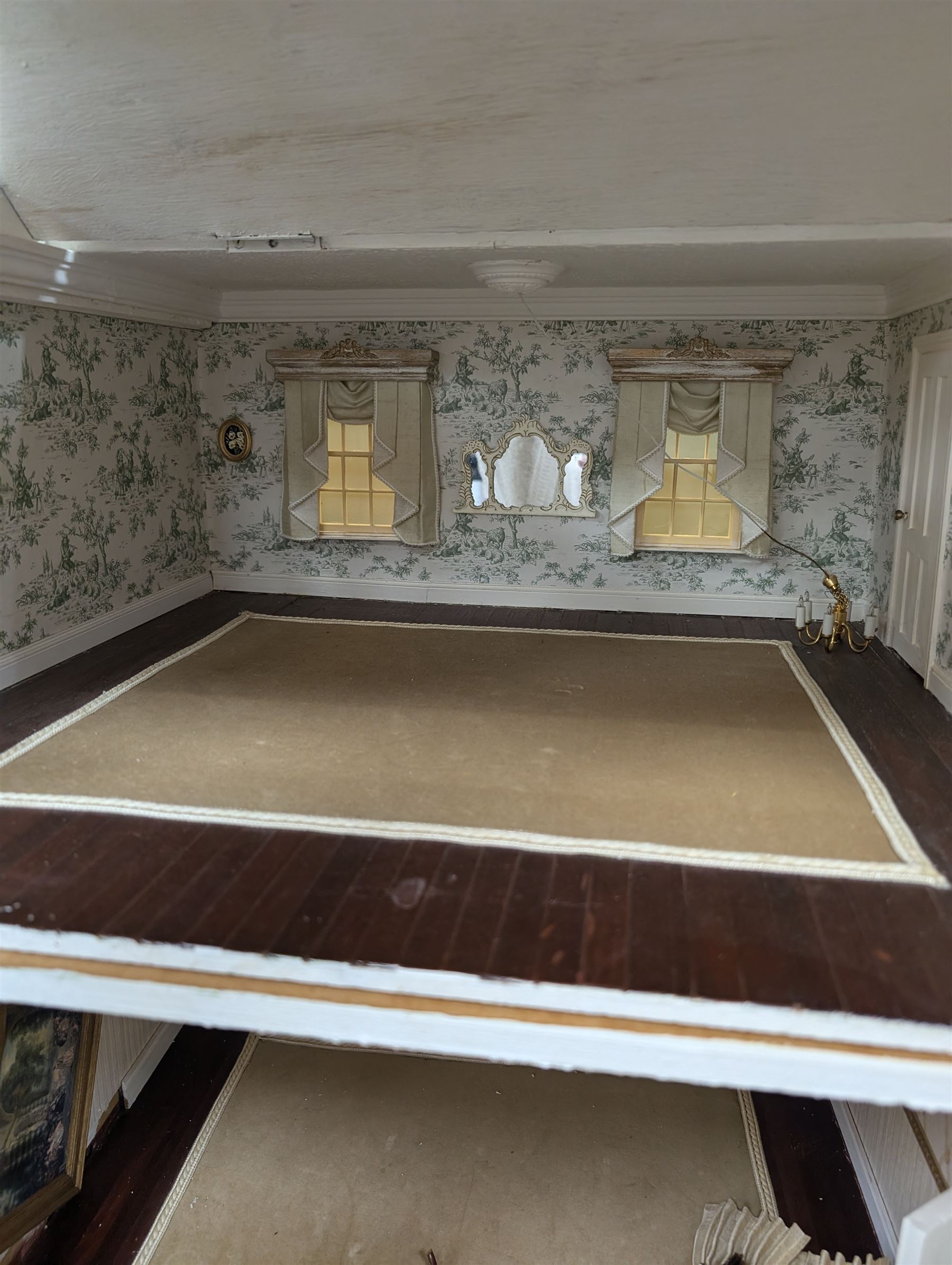 Two modern three storey dolls houses, each painted green with decorated interiors, both upon a single white wooden base, together with a large collection of dolls house furniture, accessories and figures 