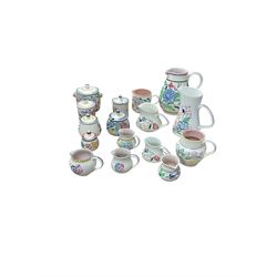 Poole Pottery, floral pattern, including five preserve pots and ten jugs of various sizes 