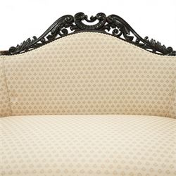 Victorian mahogany upholstered settee, the shaped back with pierced foliate carved cresting, upholstered in cream patterned fabric with serpentine seat, on cabriole front legs with brass castors