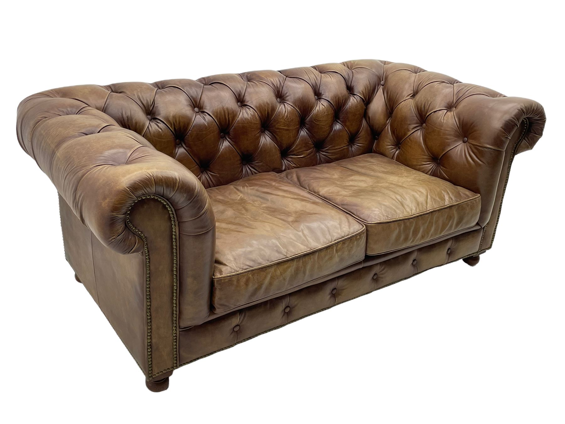 HALO - Chesterfield style two seat sofa upholstered in buttoned brown leather with stud work, on turned feet with castors