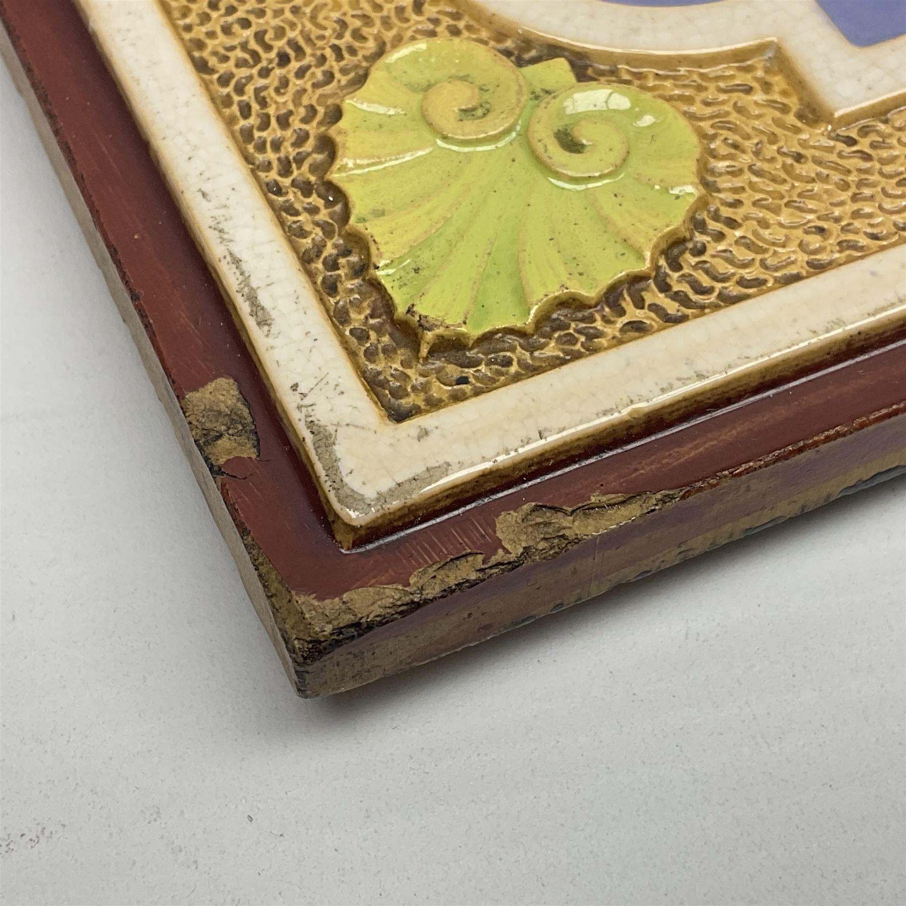 19th century Minton & Co majolica tile, decorated in relief with a bird upon a fruiting branch against a blue ground, with textured ochre border and anthemion to each corner, impressed mark verso, H19.7cm