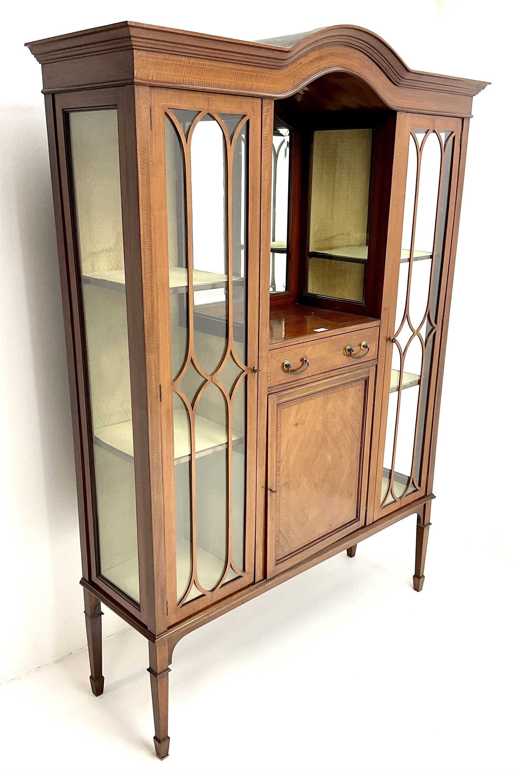 Edwardian inlaid mahogany display cabinet with ‘Shepard, Bennington & Co. Doncaster’ makers plaque, central bevel edge mirror flanked by two glazed doors enclosing two lined shelves, single drawer above cupboard on square tapering supports with spade feet