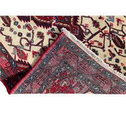 North West Persian Saveh crimson ground runner rug, the three lozenge pole medallions in an ivory field, surrounded by stylised plant motifs, the guarded border decorated with repeating geometric patterns