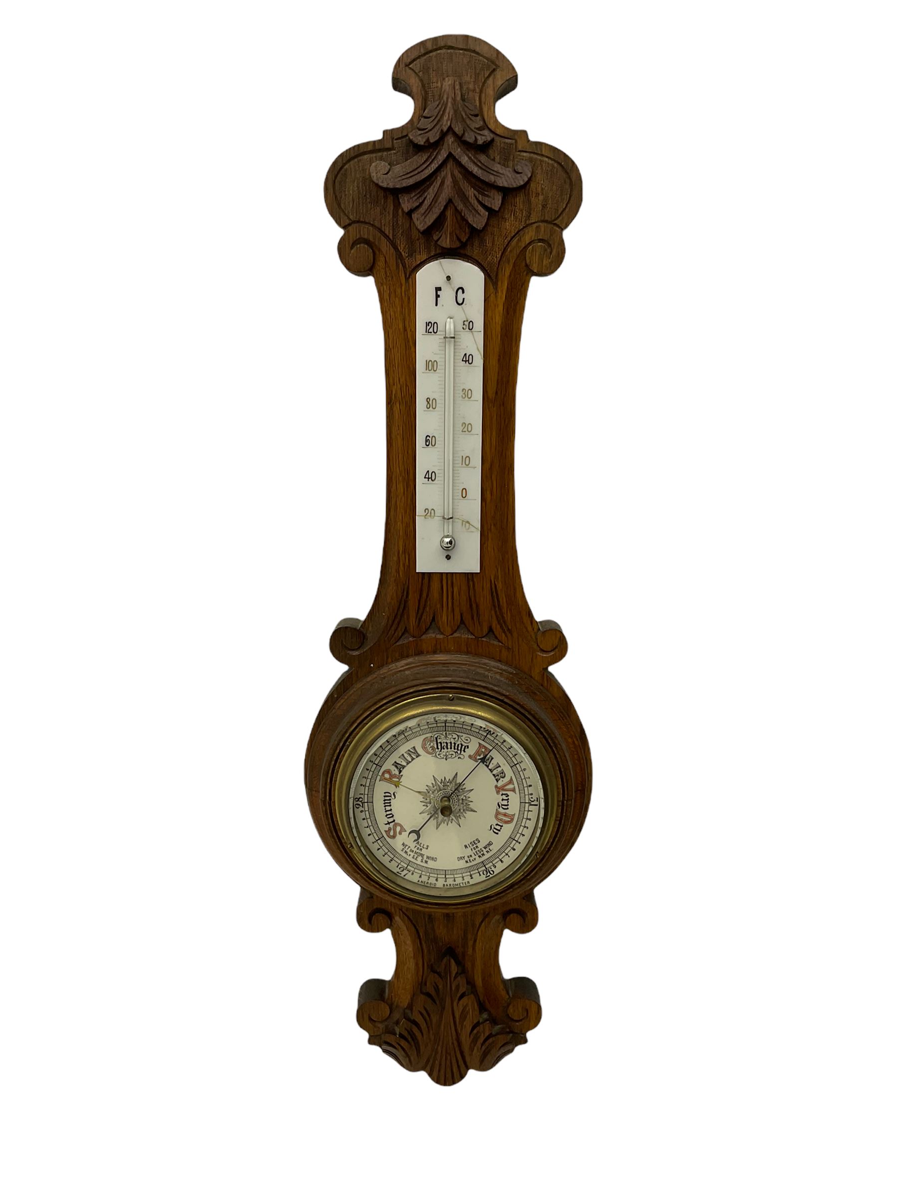 A carved oak cased aneroid barometer with a 5” register, measuring