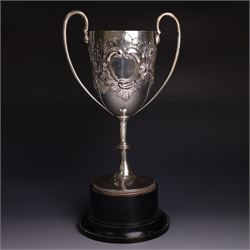 Edwardian silver twin-handled trophy, with embossed floral and scrolling decoration, upon ...