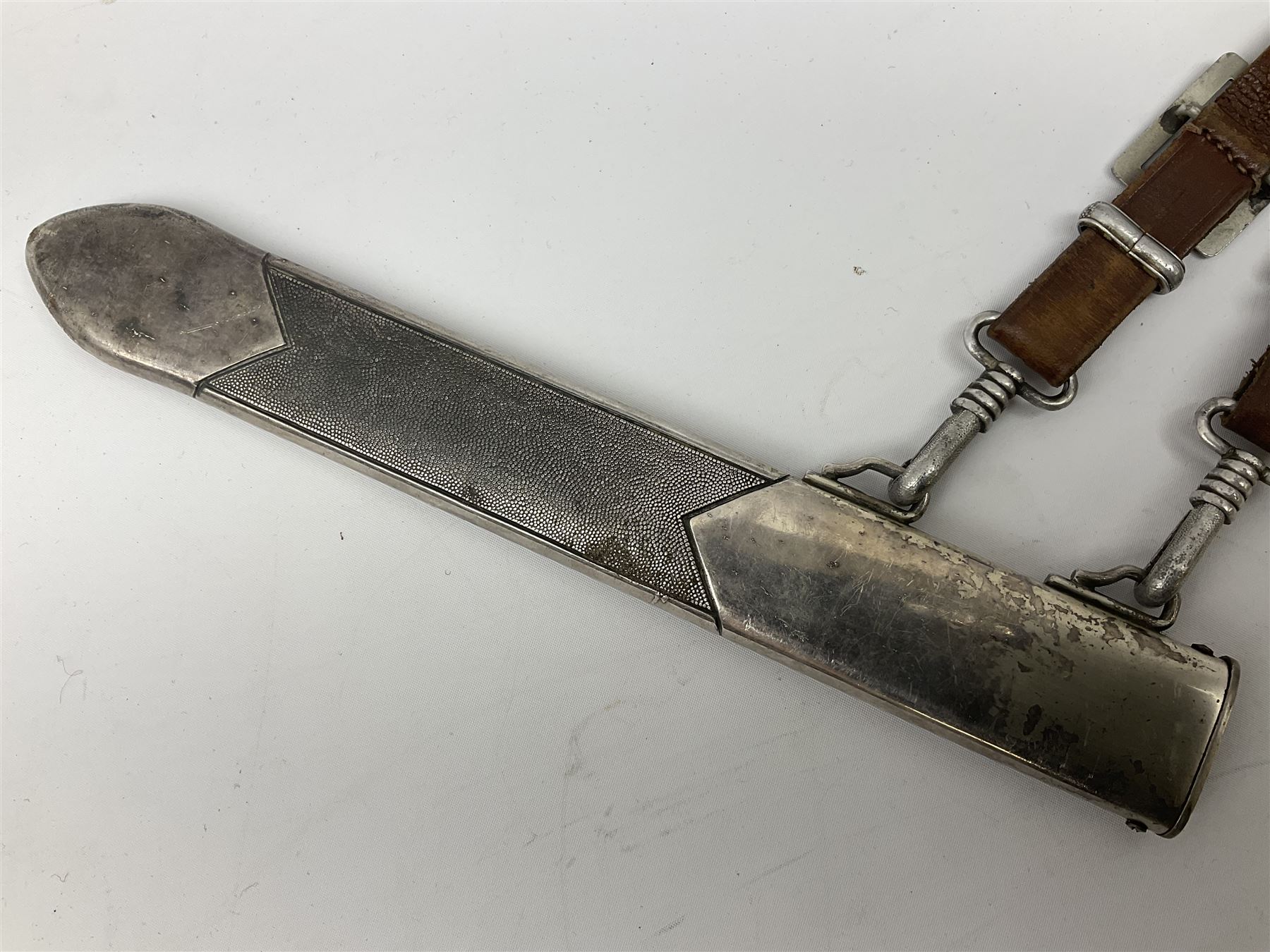 German Reichsarbeitdienst RAD Leader's Hewer dagger, the 26cm single edged scimitar shaped blade with narrow fuller, etched Arbeit adelt; by E.D. Wusthof, Solingen; the aluminium hilt with spade and wheat ear langet; two piece white plastic grip and eagle head pommel; pebbled steel scabbard engraved with ears of wheat and strapwork with double leather hangers L40cm overall