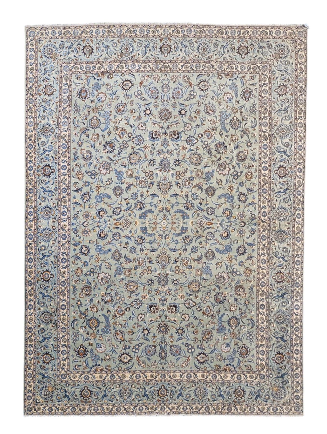 Central Persian Kashan hand-knotted carpet, pale blue field decorated with an all-over scrolling floral vine design incorporating stylized palmettes, rosettes and foliate sprays enclosed by a conforming floral vine border between multiple guard stripes, with cotton fringe ends 