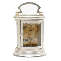 20th century-Silver plated 8-day timepiece carriage clock in an oval case, enamel dial with Roman numerals, minute track and steel moon hands, with an oval viewing class to the lever platform escapement. With key.