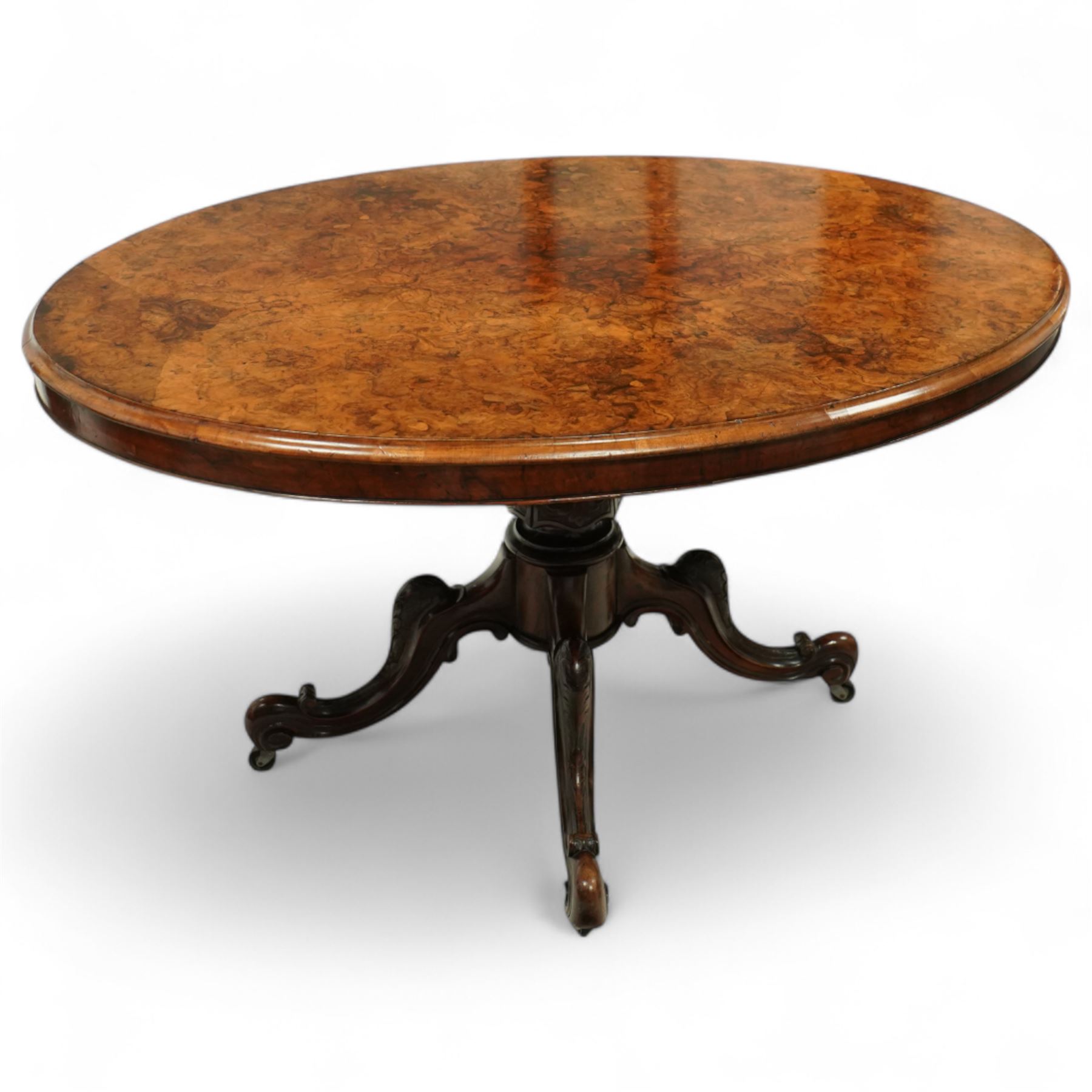 Victorian 19th century burr walnut oval centre table, hinged top above a carved pedestal supported on a scrolled carved quadruped base