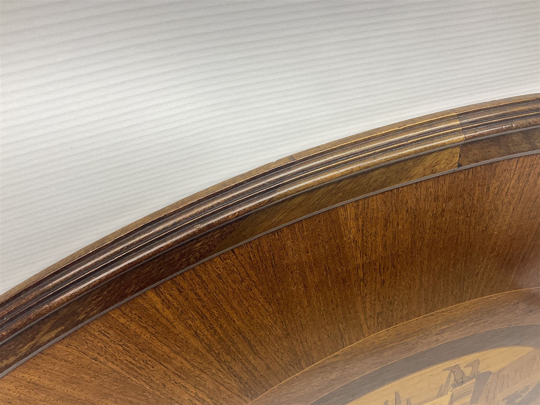 Late 19th/early 20th century mahogany and marquetry inlaid tray, of oval form with twin scrolled handles and moulded border, the central panel inlaid with figures seated at a table drinking tea, L99cm