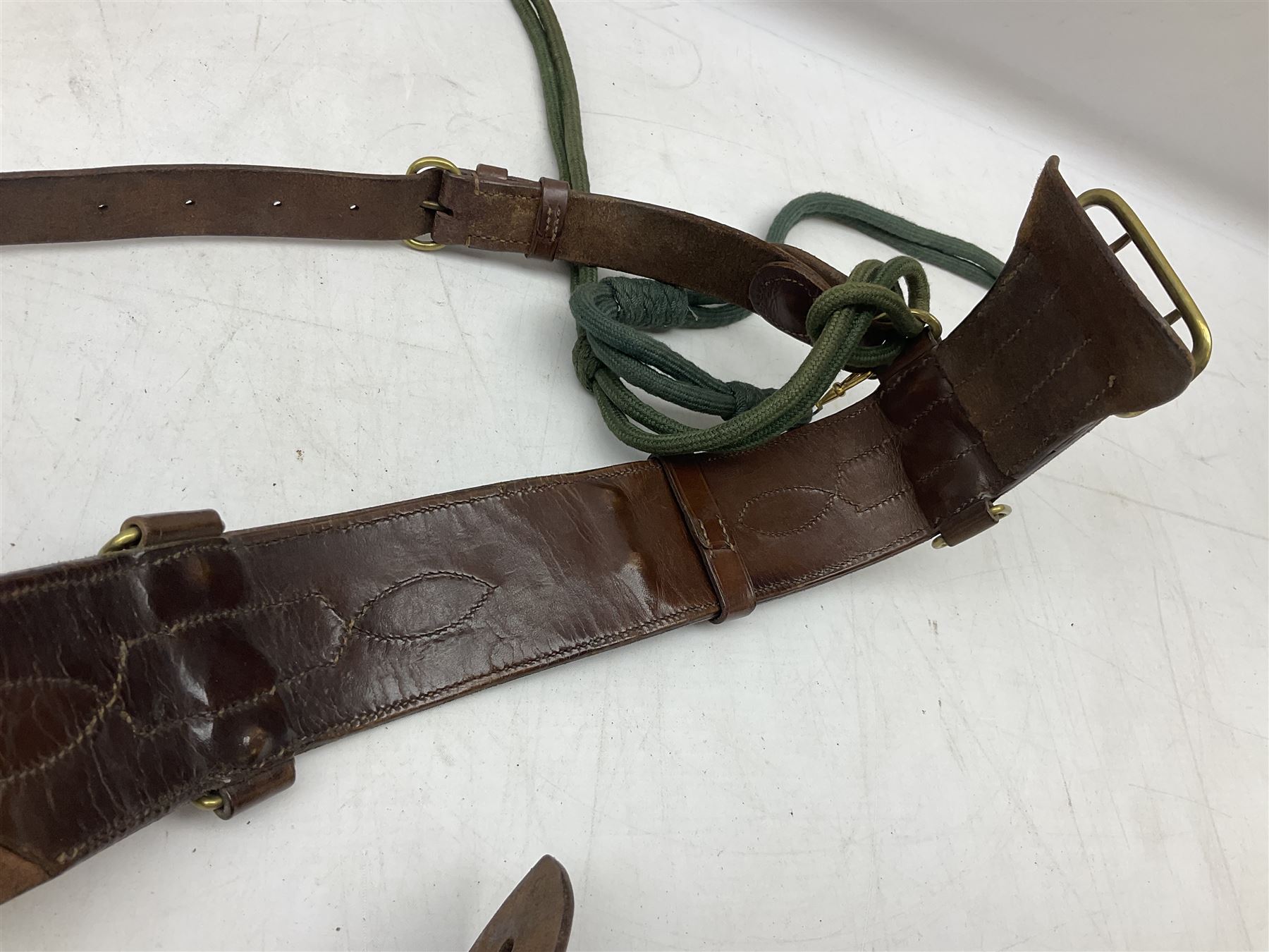 British Army Officers Sam Browne leather belt with shoulder strap; and webbing belt with Potter London Staybrite buckle for 19th Regiment of Foot (Green Howards) with various markings (2)