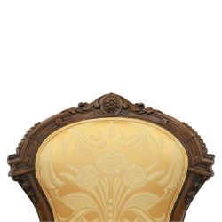 Victorian carved walnut open armchair, shaped and moulded frame with foliate carved cresting rail, upholstered back and seat in yellow damask fabric, scroll arms with padded rests, carved cabriole supports terminating in ceramic castors