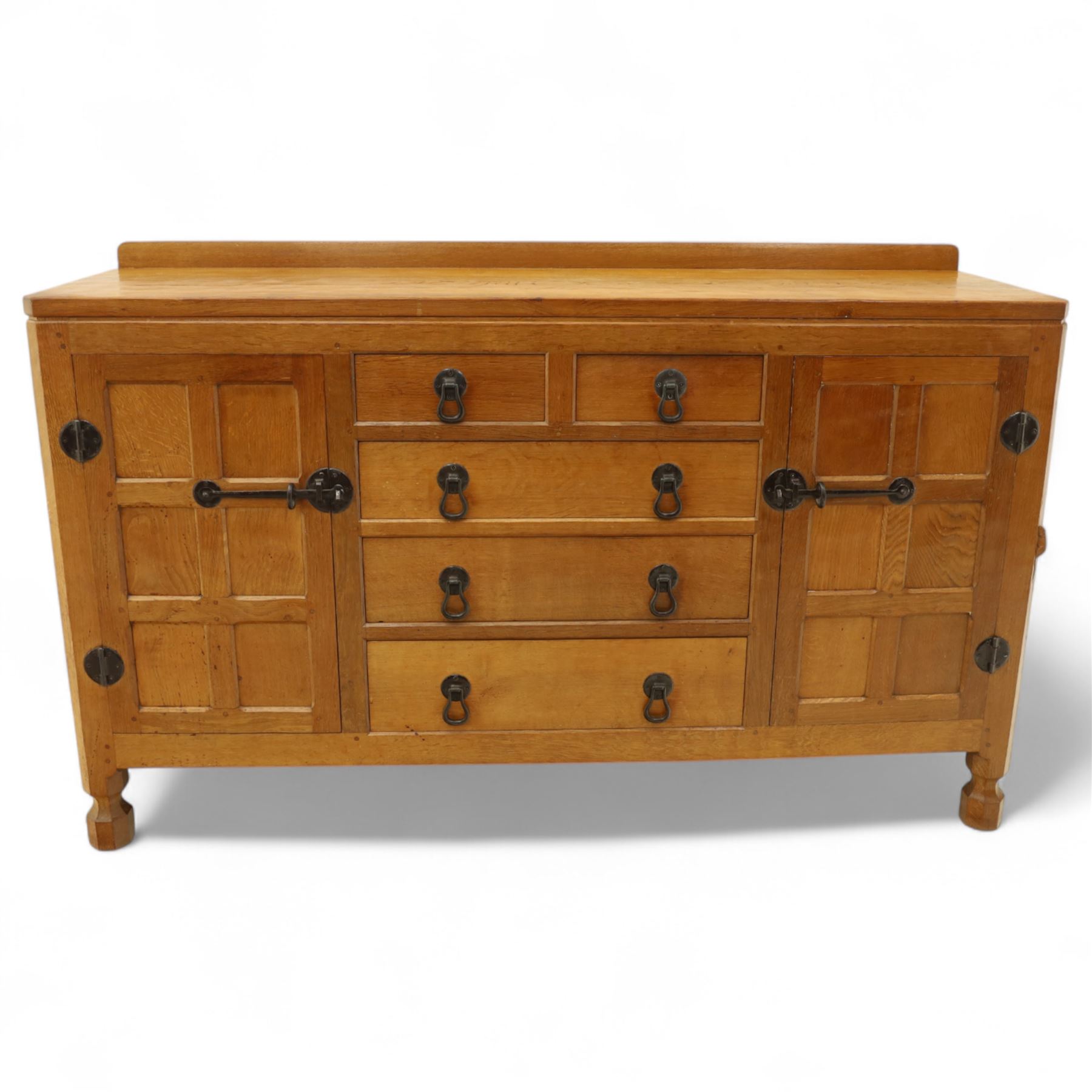 Mouseman - oak sideboard with adzed top and raised gallery back, over two short drawers and three long drawers, flanked by panelled cupboard doors with wrought iron fittings, on octagonal feet, carved with the signature mouse to the right-hand door