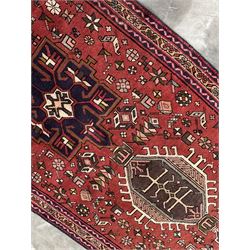 Persian Karajeh red ground runner, decorated with multiple stylised medallions and motifs