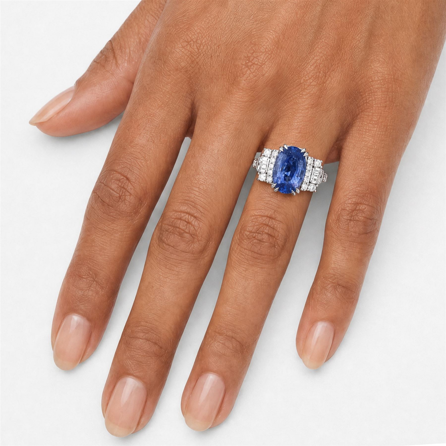 18ct white gold Ceylon sapphire and diamond dress ring, single oval cut sapphire of 4.65 carat, either side set with round brilliant cut and baguette cut diamonds and diamond set shoulders, stamped 750, total diamond weight 0.77 carat, with World Gemological Institute report