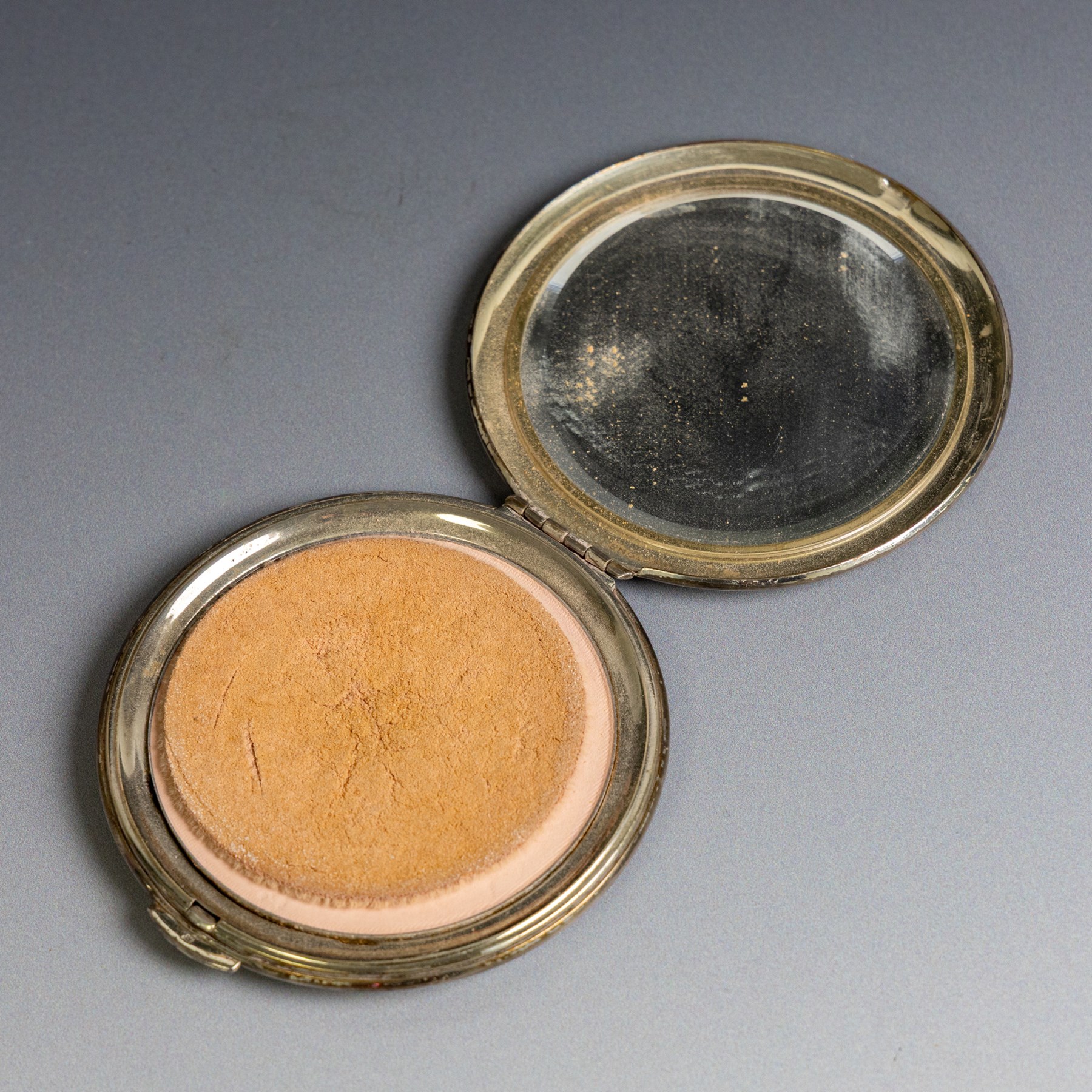 Two silver compact mirrors, comprising a Kigu powder compact with engine turned decoration and a compact mirror with floral decoration, both hallmarked