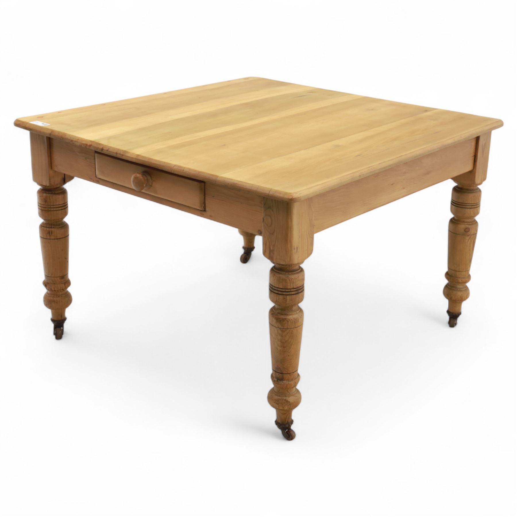 Contemporary pine kitchen table, rectangular top with moulded edge, fitted with single drawer, raised on turned supports with ceramic castors

