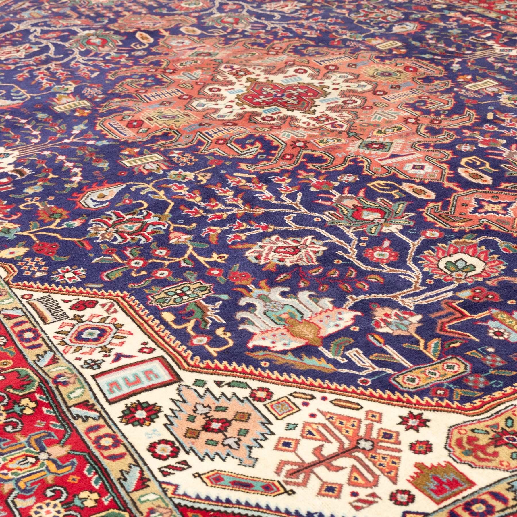 North West Persian carpet, the indigo field centred by a large terracotta and ivory medallion with matching pendants, decorated throughout with stylised palmettes, flowerheads and branching foliage, ivory geometric floral spandrels, enclosed by a red palmette border and narrow patterned guard bands