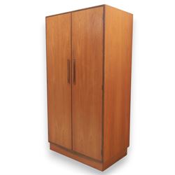 G Plan - 'Fresco' teak double wardrobe, twin doors enclosing a single clothes rail, on a recessed plinth base with castors beneath  