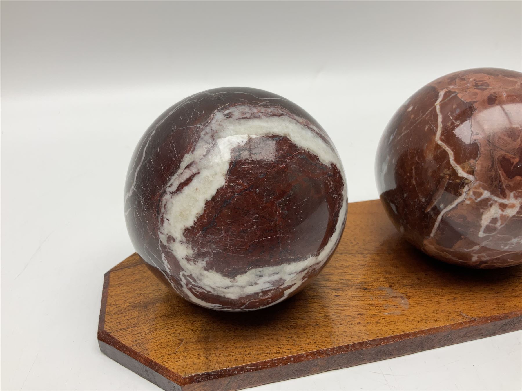 Set of three marble spheres on a elongated octagonal wooden base, H12cm