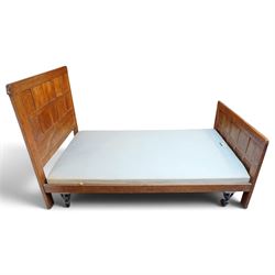Mouseman - pair of 1930's adzed and panelled oak single beds, the head and foot-boards with arcade-carved cresting rails above adzed panels, with Vibase mattress supports, carved with mouse signature, by the workshop of Robert Thompson of Kilburn