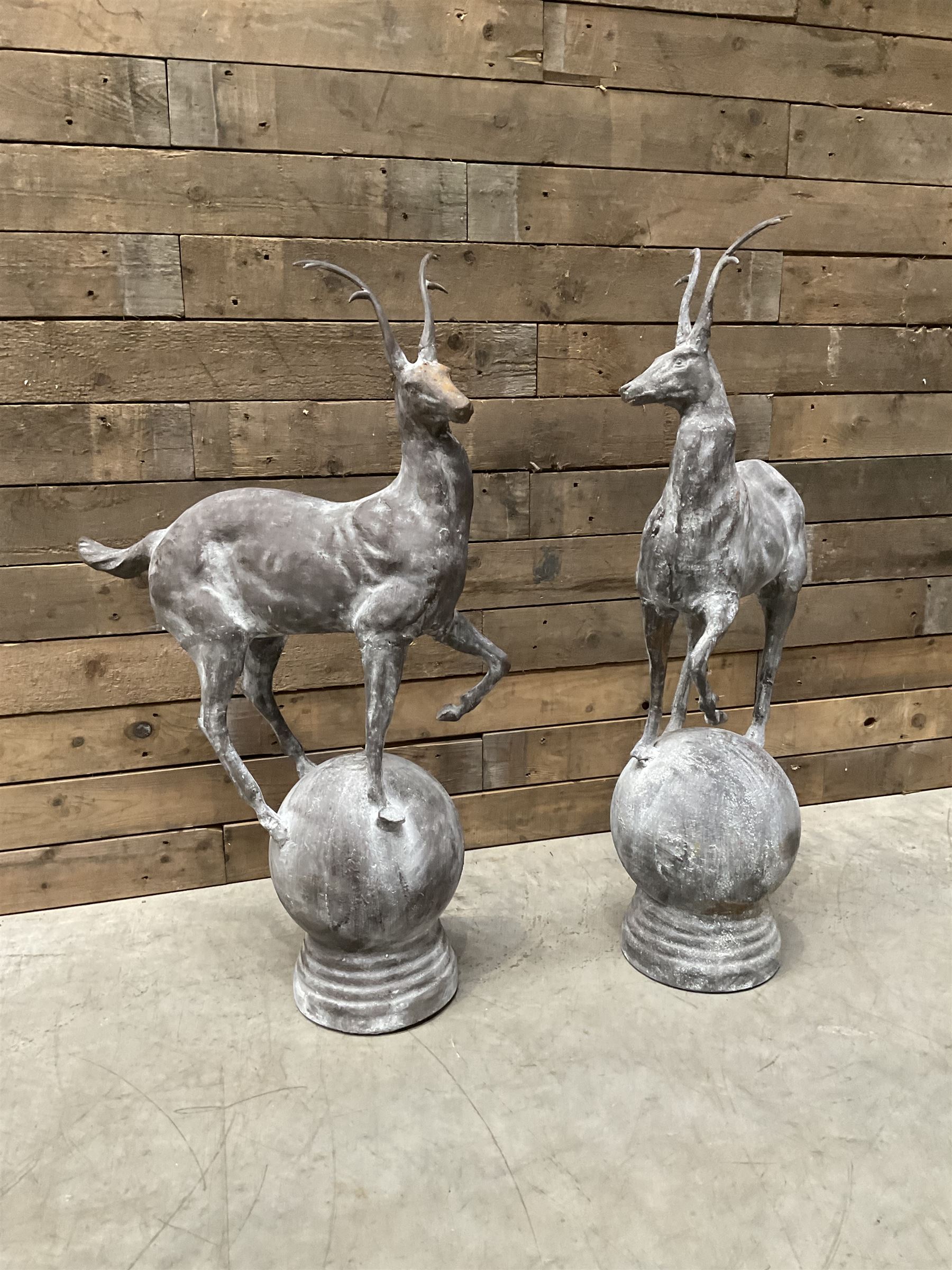 Pair of cast iron garden Stag figures or gate finials, raised on spherical ribbed base 