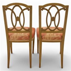 Edwardian pair of satinwood side chairs, each with shaped crest rail above an intertwining oval pierced splats centred by a floral patera, upholstered drop-in seats, raised on cabriole supports with applied floral mounts to the knees