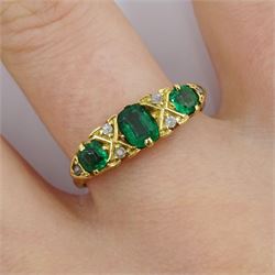 Early 20th century 18ct gold three stone emerald ring, with six diamond accents set between