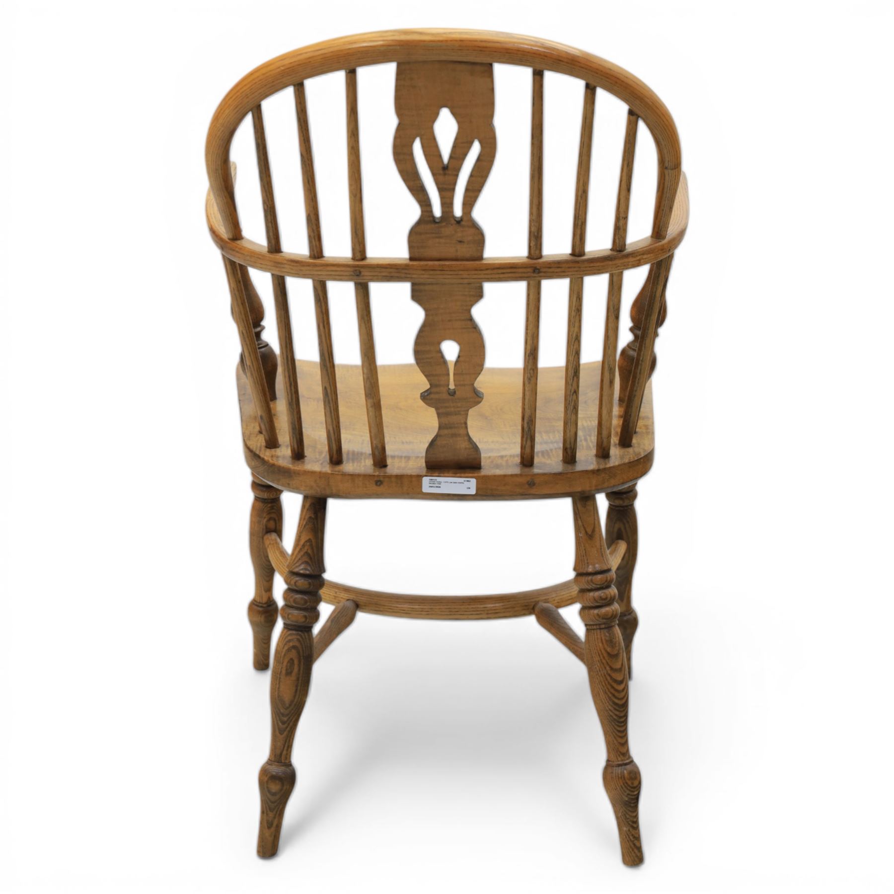 Late 20th century elm and beech low back country Windsor armchair, the arched hoop back with central pierced splat and turned spindles, shaped arm rail on turned supports, saddle seat, raised on turned legs united by a crinoline stretcher