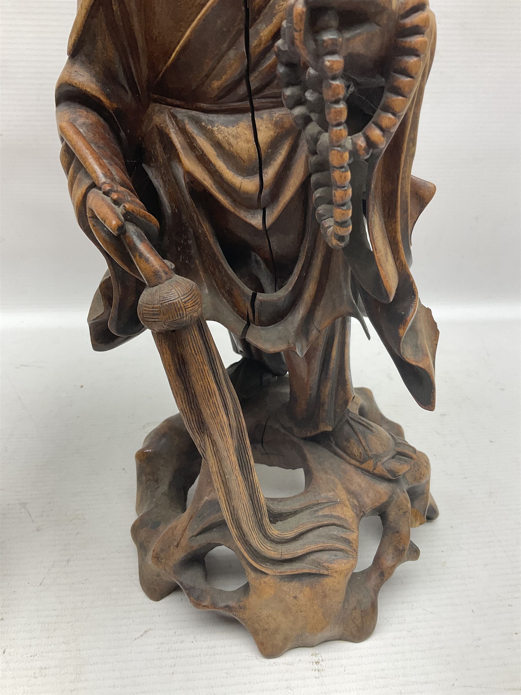Pair of Japanese carved wooden figures, modelled as merchants in traditional dress, upon pierced naturalistic bases, tallest H39cm