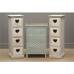  Two narrow four drawer chests with pierced heart handles (W25cm, H80cm, D28cm), and a Lloyd Loom style wicker linen bin  