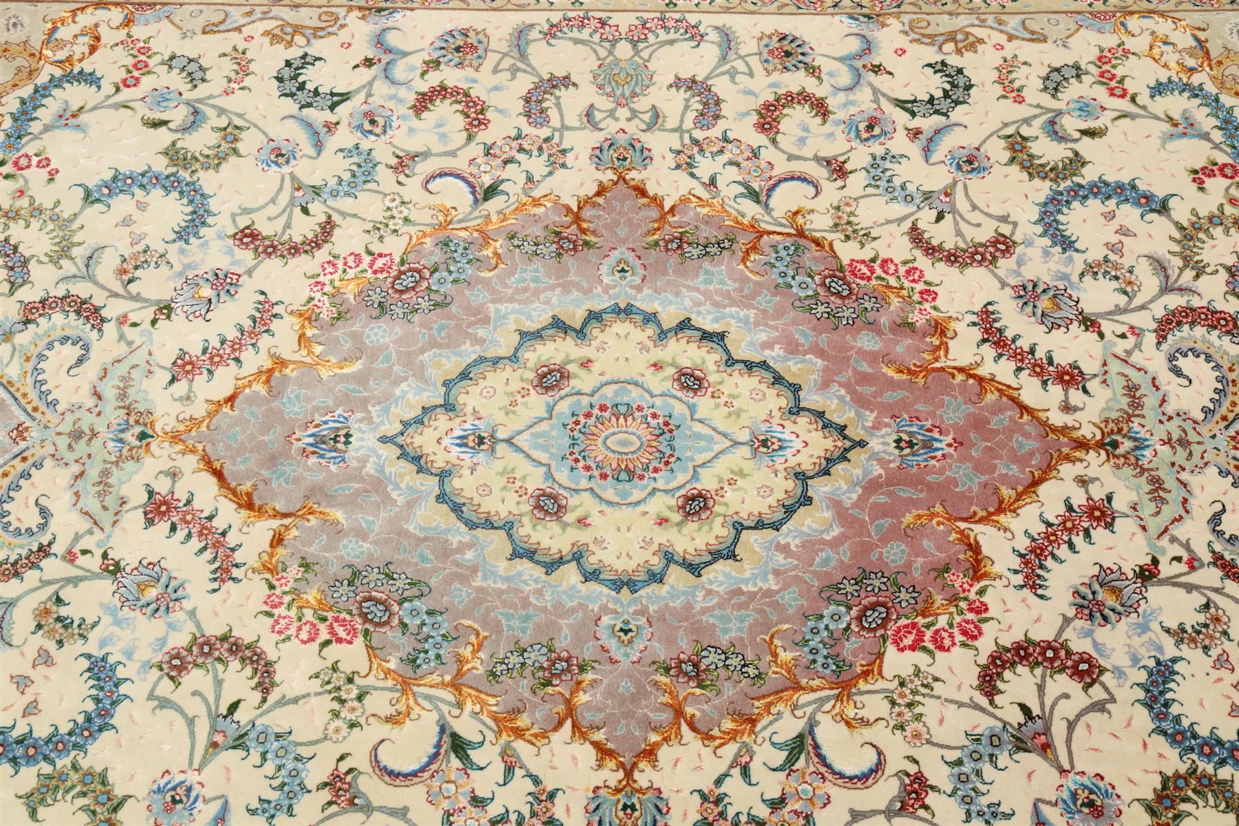Fine Persian silk inlaid ivory and rose ground Tabriz rug, the busy field decorated with a central foliate pole medallion surrounded by scrolling foliage with trailing flowerheads and bouquets, the multiple guard lines filled with repeating scrolling palmettes and interlocking floral motifs