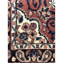 Persian Herati design indigo and red ground carpet, decorated with floral motifs, arched border