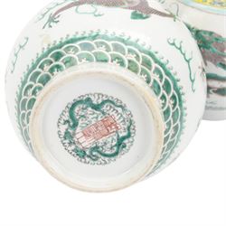 Pair 20th century Chinese famille verte bottle vases, each decorated with green and purple dragons chasing pearls amidst auspicious flames, the neck with yellow and green stylised foliate and cell borders, and the white glazed body incised throughout with fan shapes, each with red character mark beneath flanked by green dragons, H38cm

