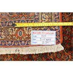 North West Persian Bidjar hand-knotted runner, terracotta field with a repeating mahi design of stylized rosettes and angular floral motifs within a lattice incorporating navy and ivory highlights, ivory principal border with a continuous angular vine of palmettes and serrated leaves, flanked b narrow guard brdoers, with cotton fringe ends 