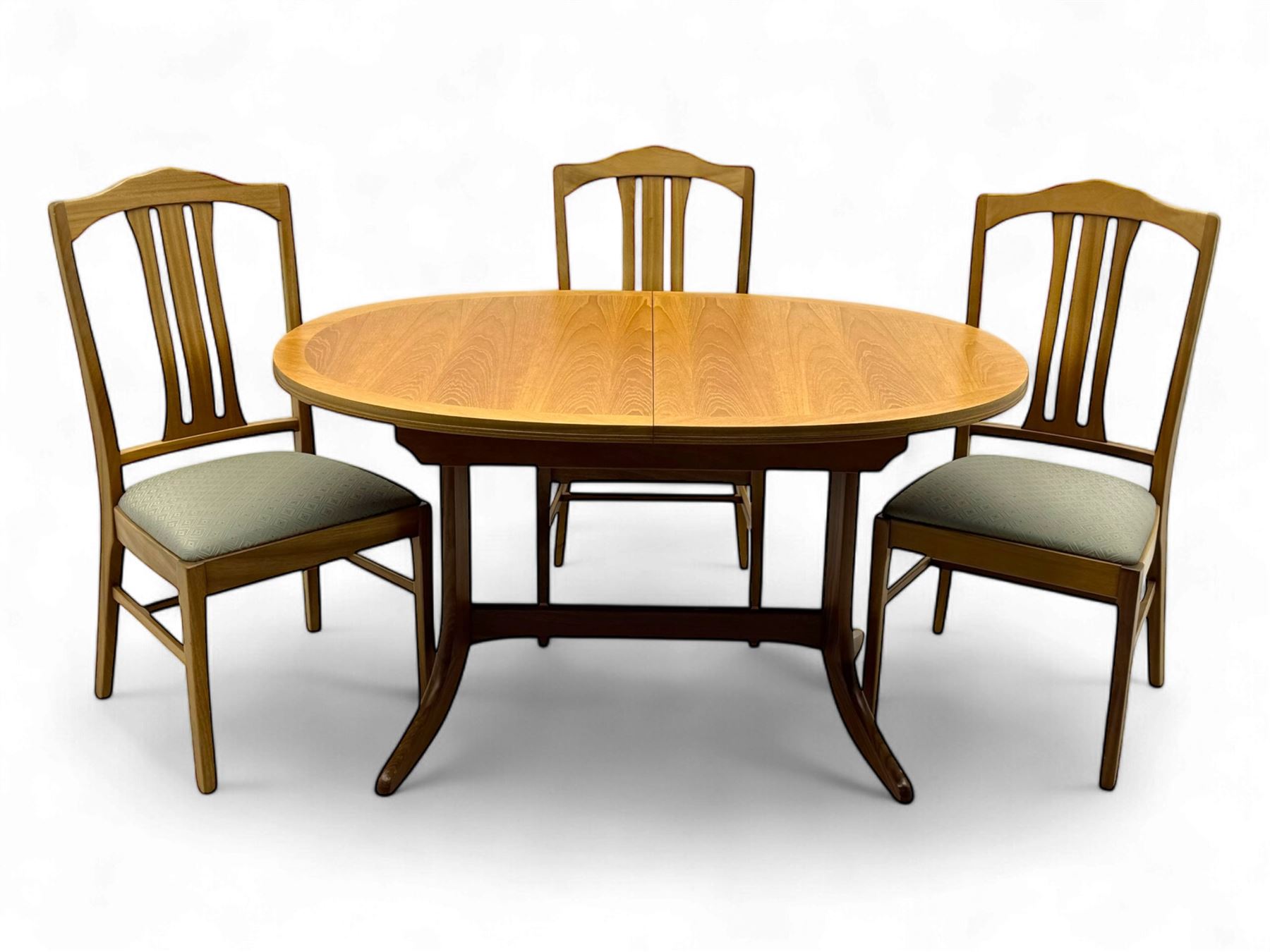 G-Plan - mid-20th century teak extending dining table, oval top with concealed central butterfly leaf extension, raised on splayed supports with cross-stretcher; three dining chairs with curved top rail and vertical splats