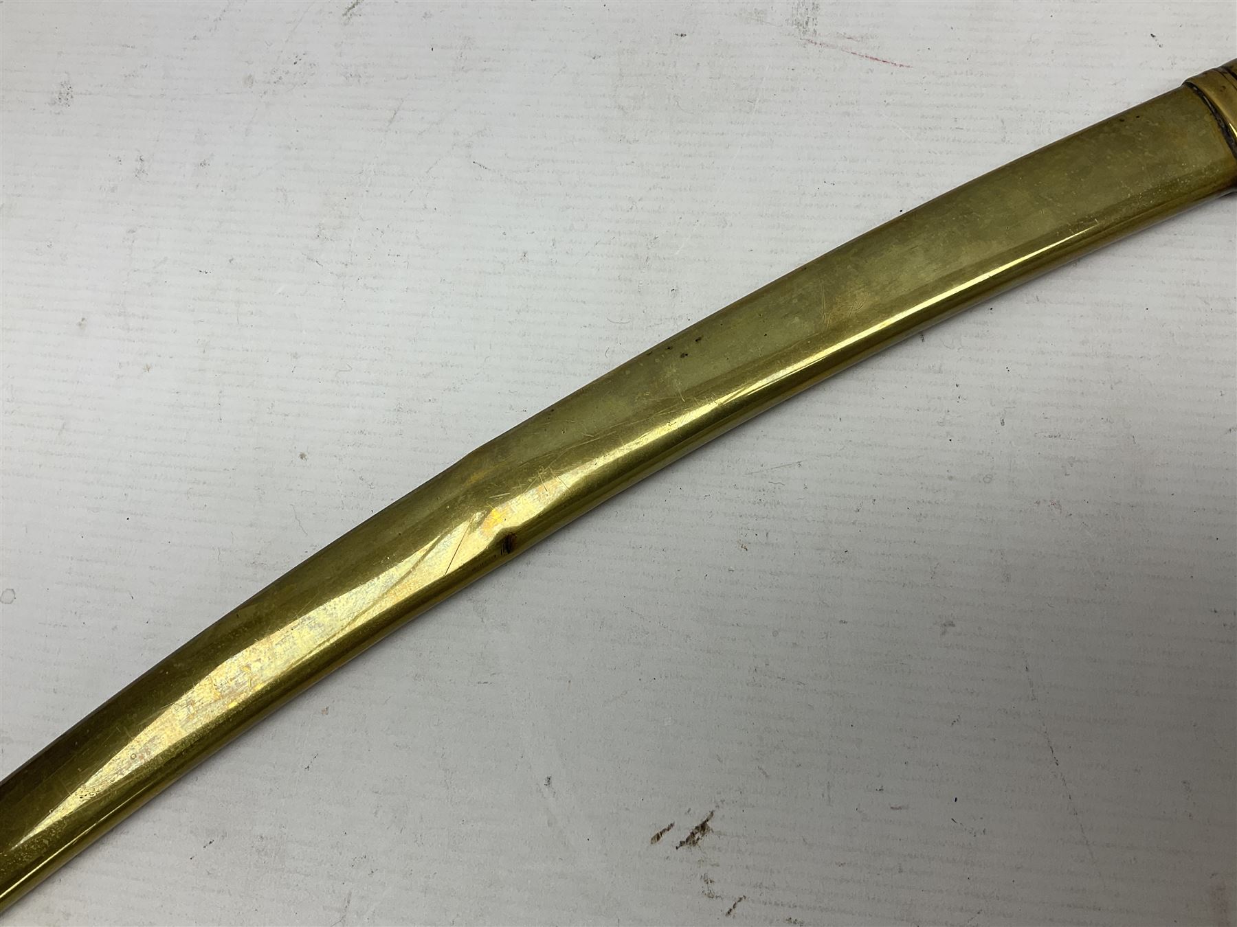 German Saxon 1st Empire Light Cavalry officer's sword c1820s, the 79cm clipped curving blade engraved with the crest of Hanover and various battle trophies with traces of blueing and gilding, brass hilt with knucklebow, foliate square langets, ornate downswept quillon, wire-bound fish skin grip with lion's head pommel; in brass scabbard with two suspension rings L95cm overall
