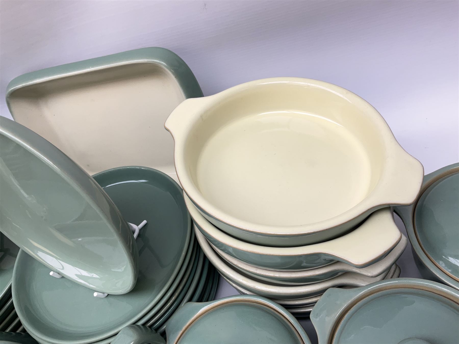 Denby Manor Green pattern part tea and dinner service, to include seven dinner plates, thirteen side plates, ten dessert plates, two oval dishes of various sizes, four cups and saucers, seven bowls with covers, two teapots etc (74)  